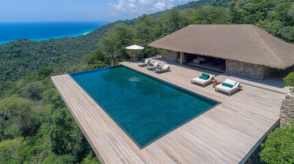 Aerial View of Luxurious Villa with Infinity Pool Overlooking Ocean and Green Hills