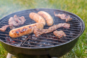 Backyard Grill cooking meat on a sunny day with smoke Rising
