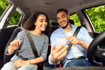 Cheerful middle-eastern guy driver travelling with his beautiful long-haired girlfriend by nice...