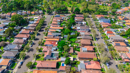Fototapeta premium Aerial Drone view of Sydney Urban Sprawl and Suburban housing Suburb of Ashbury and Croydon with roof tops, the streets and the parks NSW Australia
