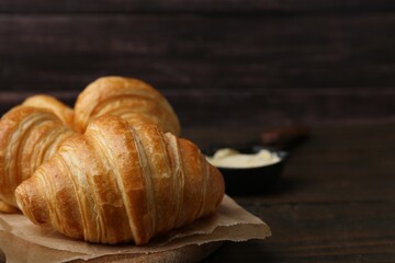 Tasty fresh croissants on wooden table, closeup. Space for text