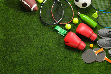 Different sport equipment on artificial grass, flat lay. Space for text