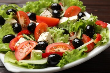 Delicious fresh Greek salad on wooden table, closeup