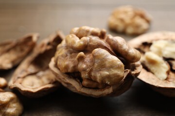 Fresh walnuts with shells on table, closeup
