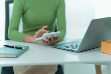 An SME business owner prepares parcels and checks online orders for delivery items for customers using a laptop computer to check package details. Close-up photo
