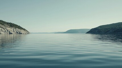 Serene lake view surrounded by lush hills under a clear sky, reflecting tranquility and nature's beauty