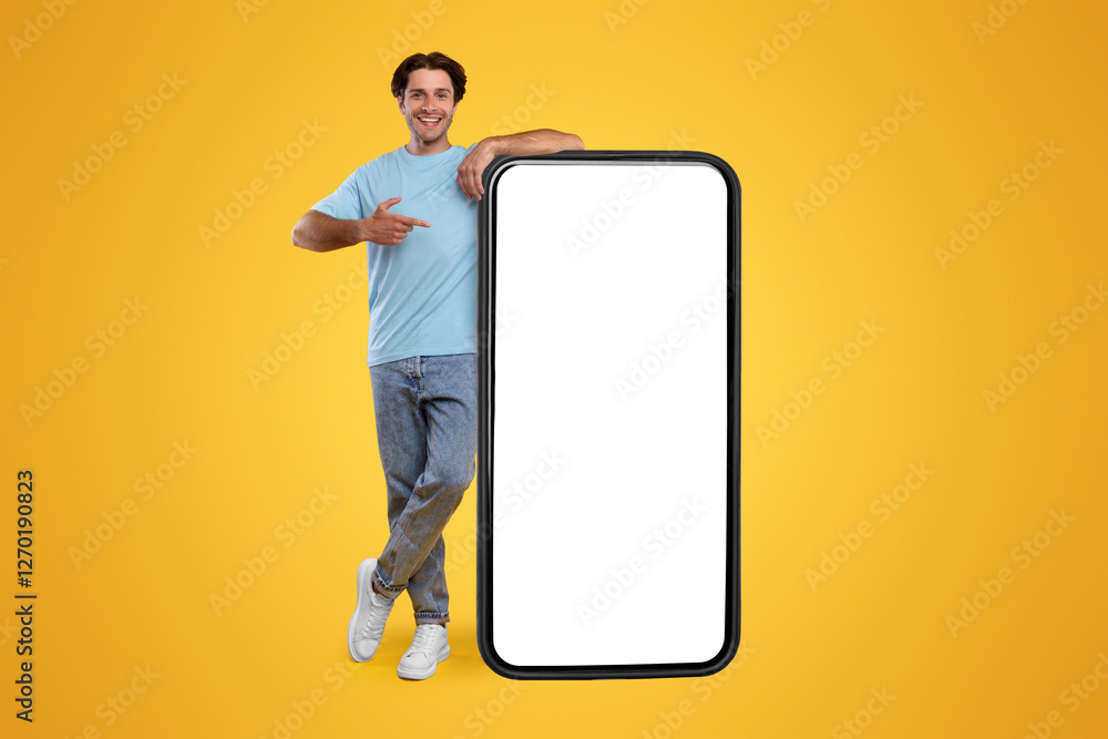 Poster Check This Website. Smiling male leaning on smart phone with white blank screen, showing device and pointing finger at gadget with empty free copy space for mock up, recommending app, full body length