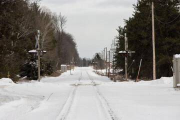 A railroad corridor and crossing in the wintertime