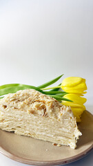 This photograph showcases a slice of Napoleon dessert cake with flaky layers and creamy filling,...