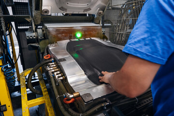 Worker using an industrial machine to form a component potentially in a manufacturing or factory setting