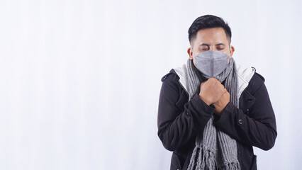 Young Asian Man Wearing Scarf and Jacket Feeling Cold Isolated on White Background