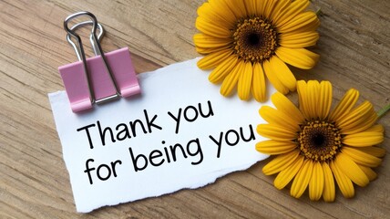 Naklejka premium Thank you note with a pink clip and yellow flowers