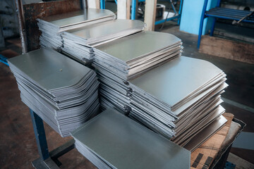 Stacks of metal plates are neatly arranged showcasing industrial precision in a workshop environment