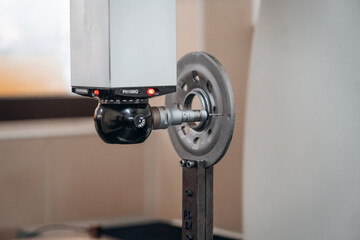 Precision measurement of a metal part using a coordinate measuring machine (CMM) in a quality control lab