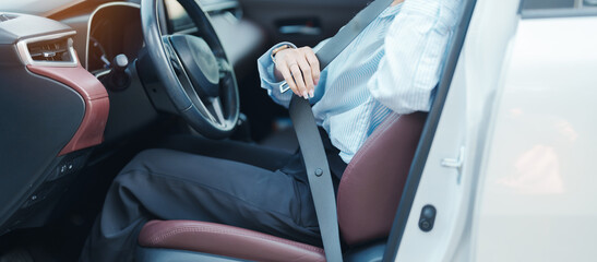 Business woman driver hand fastening seat belt during sitting inside a car and driving in the road. safety, trip, journey and transport concept