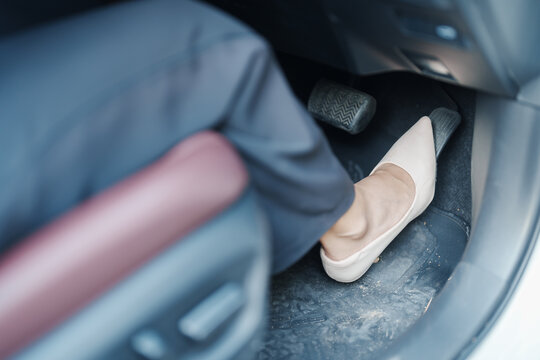 Female driver in high heels, business woman driving car and pushing car break and accelerator pedal. Safety concept