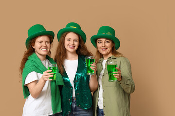 Beautiful women with beer on beige background. St. Patrick's Day celebration
