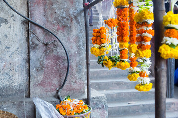 Asia, India, Mumbai. Fresh flowers for sale at street market. Strings of marigolds.