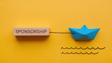 Sponsorship concept represented by paper boat and wooden block