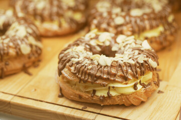 Delicious pastries topped with chocolate and almonds on wooden board
