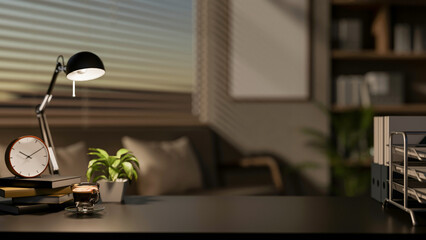 A close-up of a black desk displays decorative items, set in a contemporary dark living room.