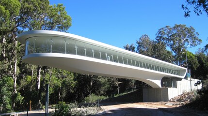 Modern architectural structure with sweeping curves set against a lush green landscape