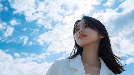 Young Asian Woman in White Jacket Against Blue Sky with Clouds