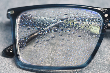 Moisture droplets collect on eyeglasses in a humid environment