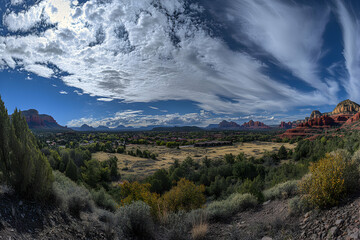Fototapeta premium Breathtaking panoramic view of Sedona, Arizona's red rock formations under a dramatic, swirling sky. A picturesque landscape showcasing the beauty of the American Southwest.