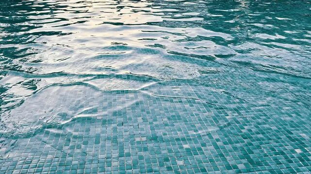A video showcases a serene pool with turquoise tiles and blue water