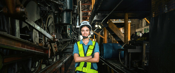 woman in a yellow vest stands in front of a train engine