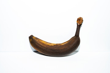  “Overripe banana with a dark, decayed texture against a white background. Conceptual still life exploring time, impermanence, and food waste.”