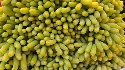 Fresh green grapes piled up for sale.