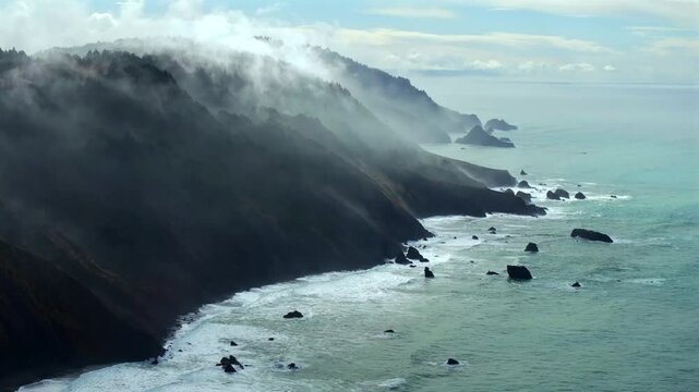 Rugged coastline Lost Coast Trail USAL Beach campground 4wd aerial drone California cloud layer blue sky mist rain fog PNW waves crashing morning Chimney Rocks nature landscape forward pan up motion