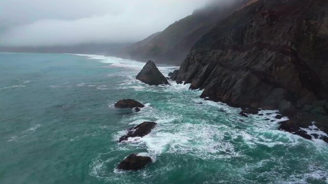 Rugged dramatic untouched coastline USAL Beach campground cloud layer mist rain fog aerial drone California PNW Lost Coast Trail morning huge surf waves boulder rocks nature landscape static shot