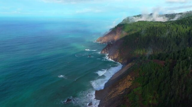 Rugged dramatic untouched coastline aerial drone California surf waves crashing boulder rocks USAL Beach campground cloudy mist fog sun PNW Lost Coast Trail morning nature landscape backwards motion