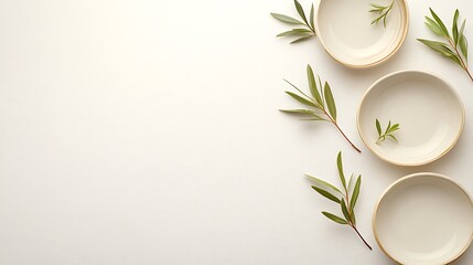 White bowls and green sprigs arranged on a white background