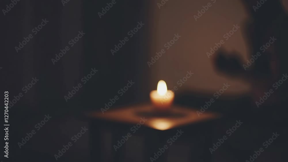 Poster a dimly lit video scene with a blurred candle on a table. shot from a low angle, creating a mysterio