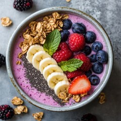 A vibrant and colorful smoothie bowl topped with granola, sliced banana, and fresh berries