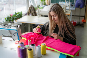 a woman carefully chooses vibrant thread colors for her sewing project, focusing intently on her task In a well-lit workshop