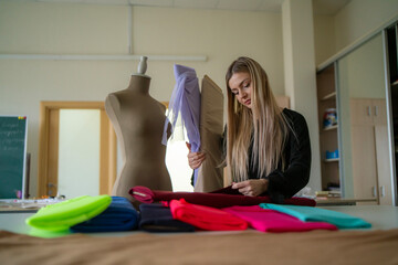tailor choosing colour of  a fabric roll while surrounded by vibrant materials in a well-lit studio...