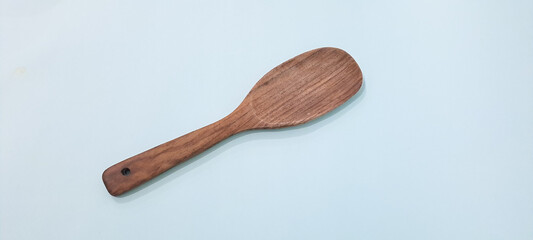spoon rice made of wood on blue background	

