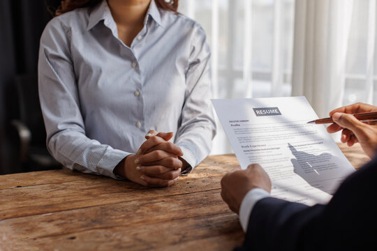 Hands of recruiter holding resume in front of candidate at desk.employee job application concept.