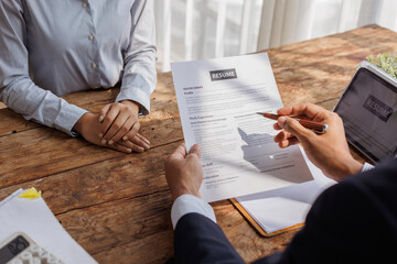Hands of recruiter holding resume in front of candidate at desk.employee job application concept.