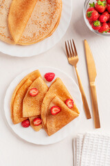 Top view of sweet homemade traditional  folded crepe or blini dessert decorated with sliced juicy...