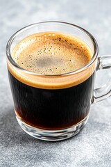 Expertly brewed espresso served in a clear glass cup, highlighting rich crema and dark liquid, perfect for coffee lovers in any caf&eacute;
