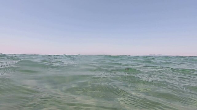 Wave on moving water surface closeup in the middle of the screen. Dikili, Izmir