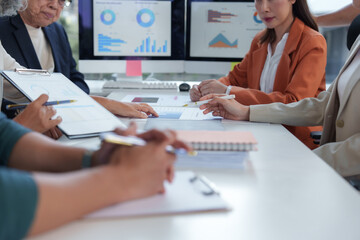 Businesswomen team analyzing financial charts and reports during a productive meeting in a modern office, fostering collaboration and strategic decision-making