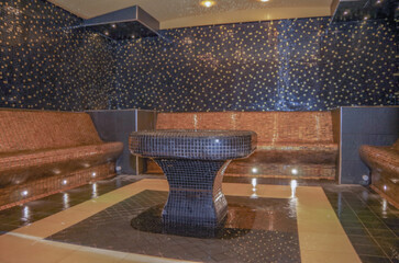 Turkish bath or steam sauna with mosaic tiles inside male locker room of spa or wellness are...