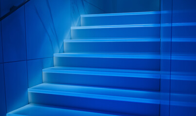 Obraz premium Modern ceramic tile staircase illuminated by LED lights for a futuristic interior design concept.